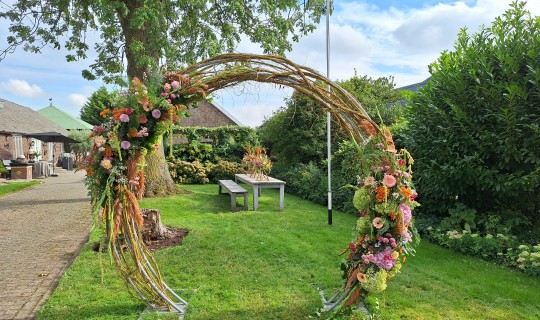 Boog van wilgen en bloemenarrangementen